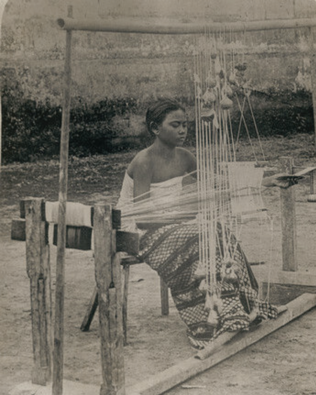 A weaver working at a traditional loom